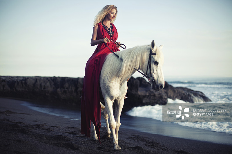 女人騎著馬沿著海灘圖片素材