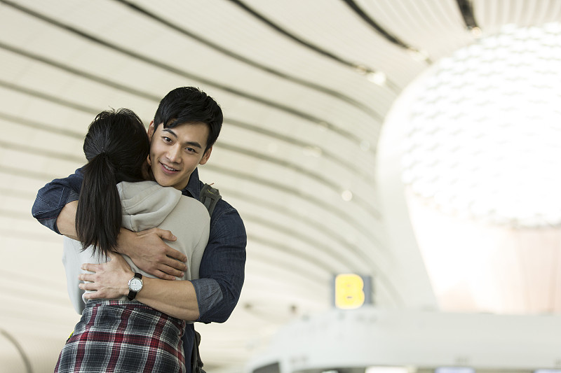 青年情侶在機場深情的擁抱圖片素材