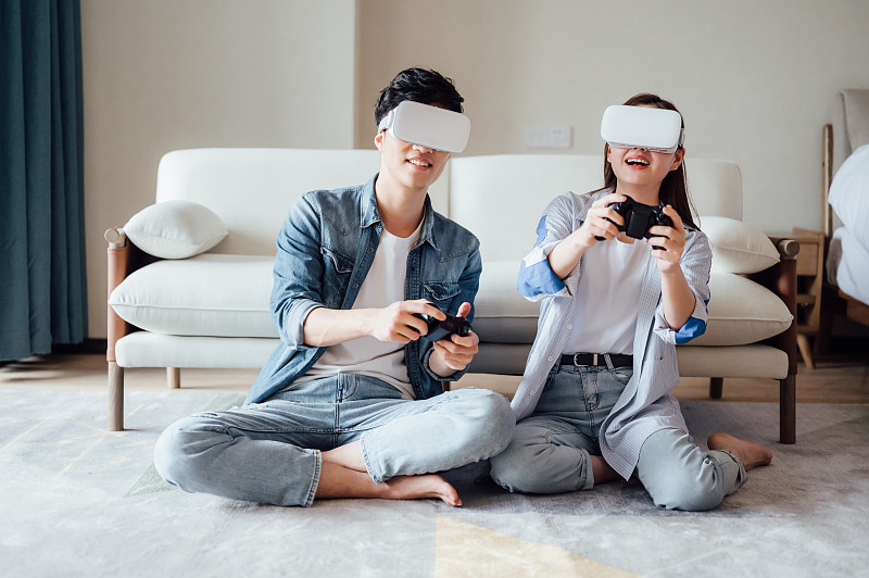 亞洲年輕情侶在家戴VR眼鏡打游戲圖片素材