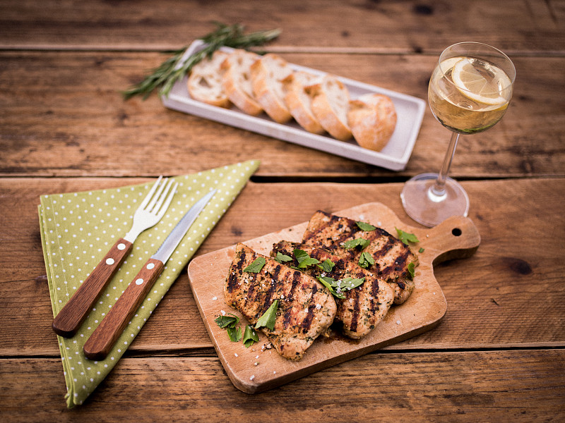 简单的夏季餐，猪肉片，切片法棍面包和葡萄酒图片下载