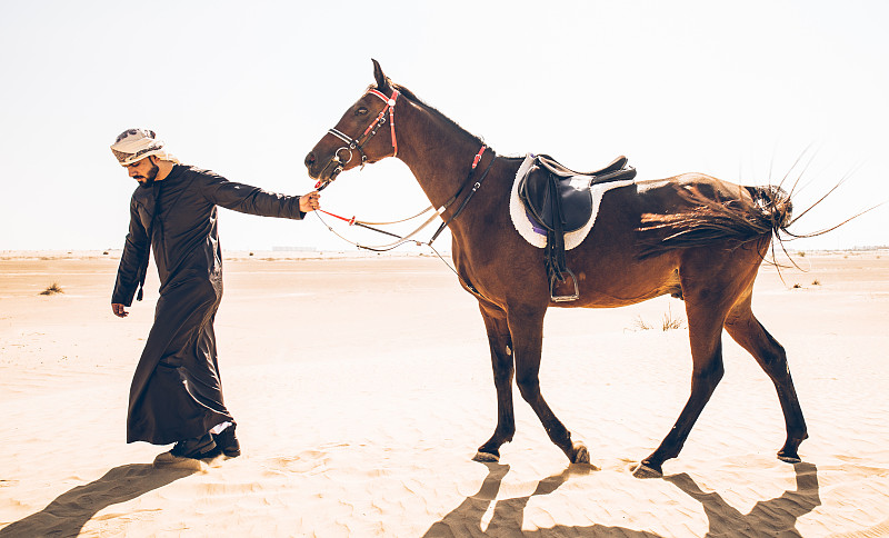 沙漠中騎馬的人圖片素材