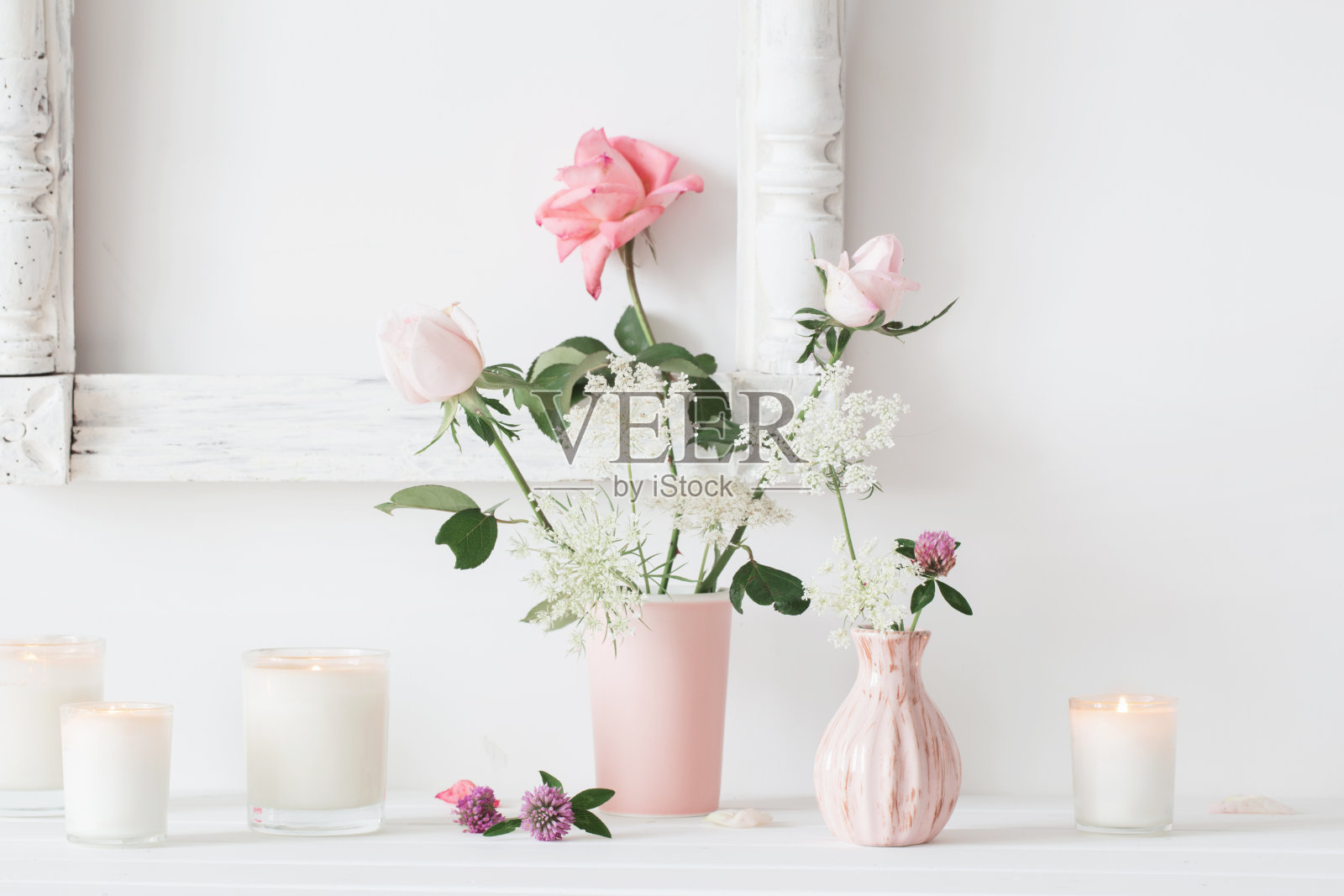 花瓶上插着花，白色背景上插着蜡烛照片摄影图片