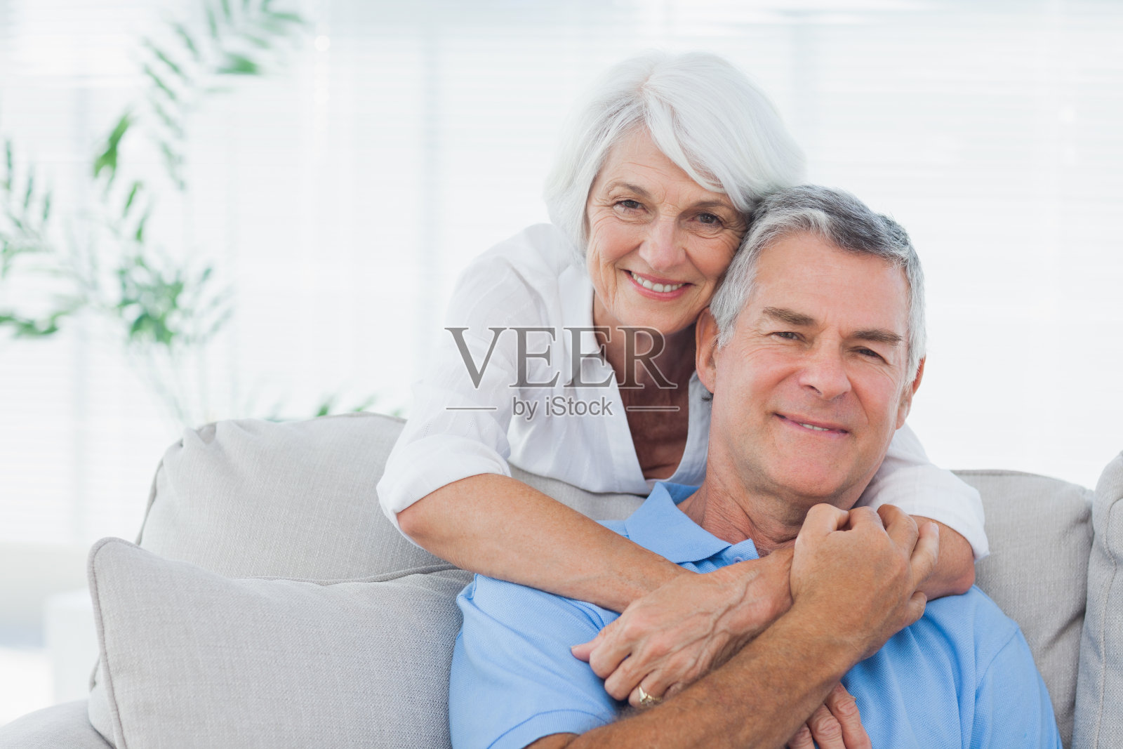 坐在沙發上的女人擁抱著丈夫照片攝影圖片