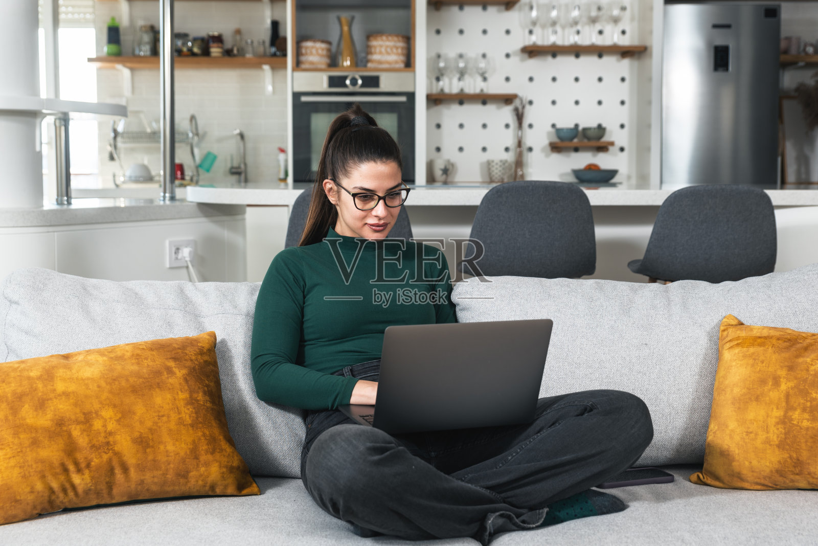 年轻成功的平面设计师女人坐在家里工作作为自由职业者在线营销网络开发者。女性企业家，从事网络教育和广告网站设计。照片摄影图片
