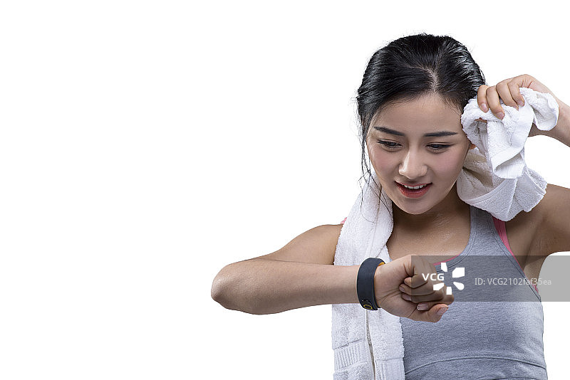 Young female athlete checking smartwatch图片素材
