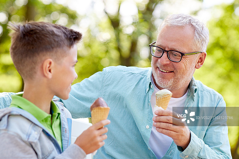 家庭、世代、沟通和人的概念——快乐的爷爷和孙子在夏季公园吃冰淇淋图片素材