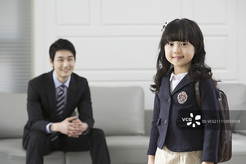 小女孩准备去上学，她的爸爸对她微笑图片素材
