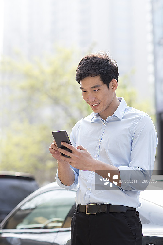 Young Chinese businessman using smart phone图片素材