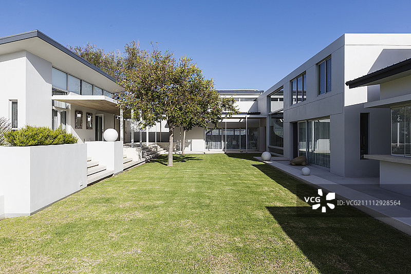 阳光灿烂的现代豪华住宅展示外观与庭院图片素材