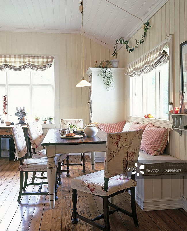 用餐区配有木制餐桌和带靠垫的长凳图片素材
