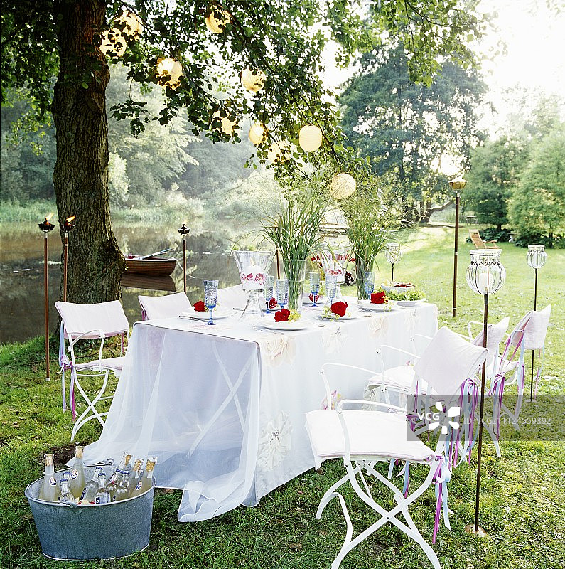 有椅子、玻璃杯、盘子和花的桌子图片素材