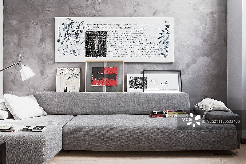 座位区采用和谐的灰色色调，沙发和大理石墙壁上的书法图片素材