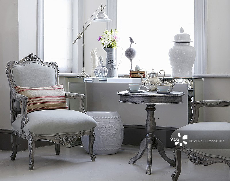 灰色的，古色古香的扶手椅和茶具搭配在窗下的边桌上图片素材