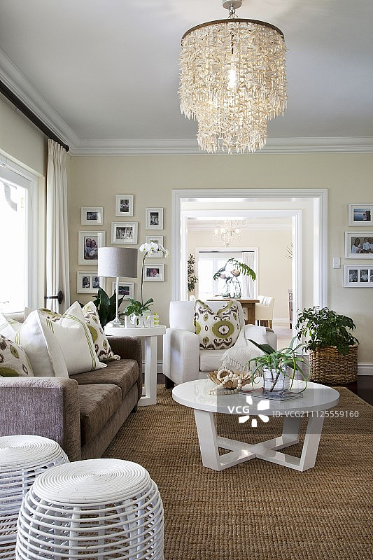 具有异国情调的客厅，顶壳灯罩，剑麻地毯和白色，现代家具图片素材