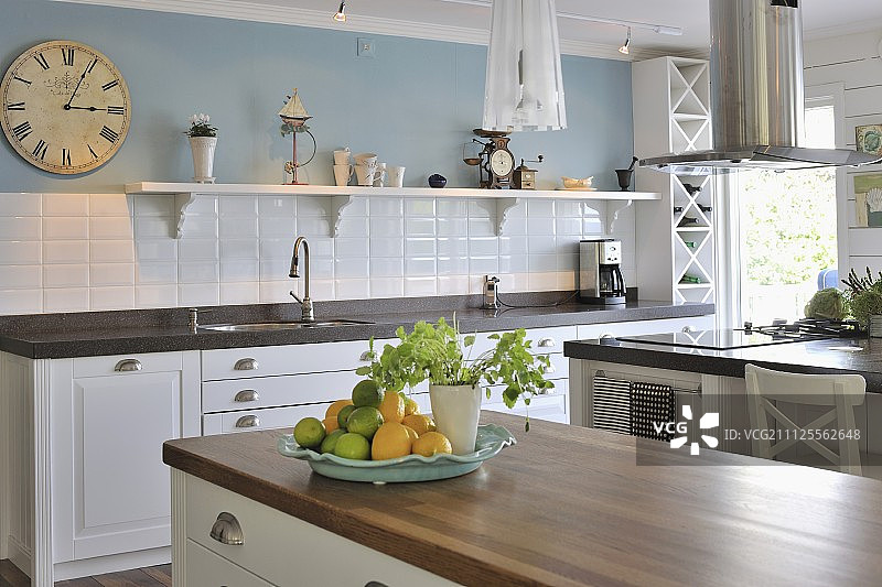 乡村别墅的厨房有白色的基础单元，白色瓷砖的防溅板和浅蓝色的墙壁图片素材