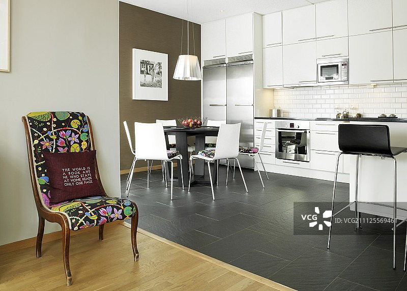 在白色的厨房餐厅前，有色彩丰富的沙发和黑色的木炭地砖图片素材