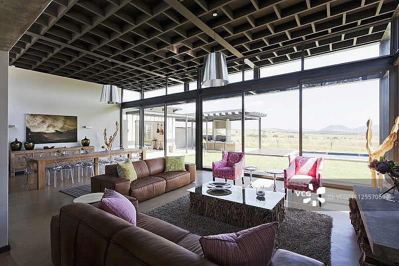 开放式的内部空间，休息区，玻璃墙与景观和格子风格的天花板在当代住宅图片素材