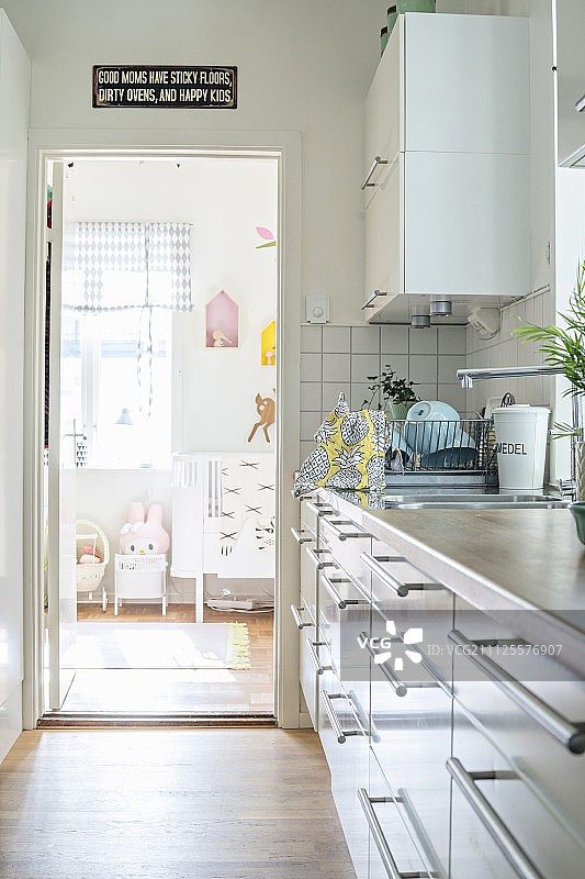 有多个抽屉和白色表面的厨房柜台;透过开着的门可以看到孩子的卧室图片素材