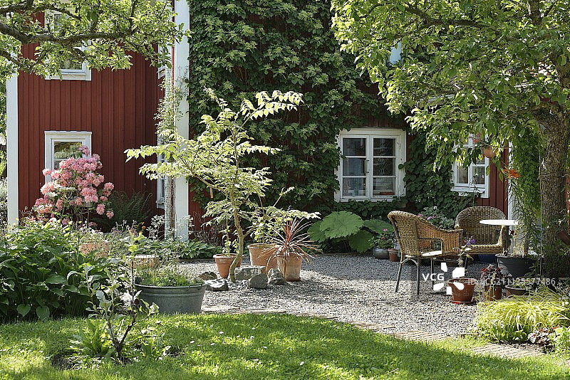 从花园到带家具的砾石露台和falu -红色木屋在夏季的氛围图片素材