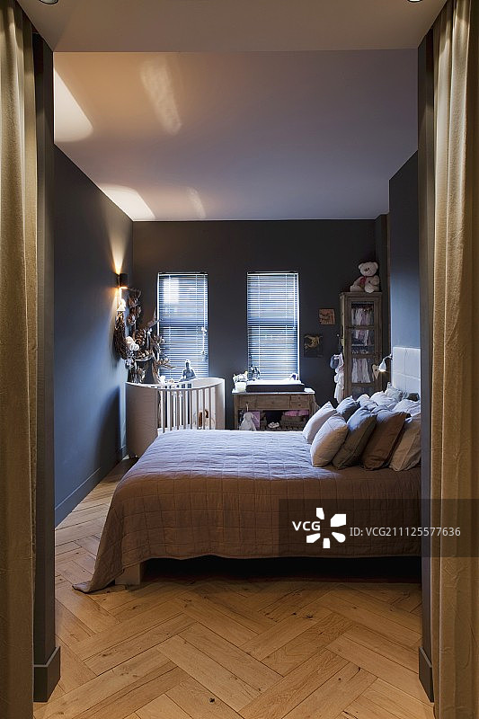 卧室里的双人床，散落着靠垫和小床，漆成深灰色图片素材