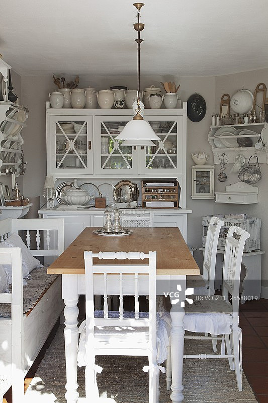 在舒适的厨房餐厅梳妆台前摆放着质朴的餐桌和白色木椅图片素材