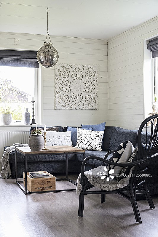 角落沙发和藤椅周围的咖啡桌在木质客厅图片素材