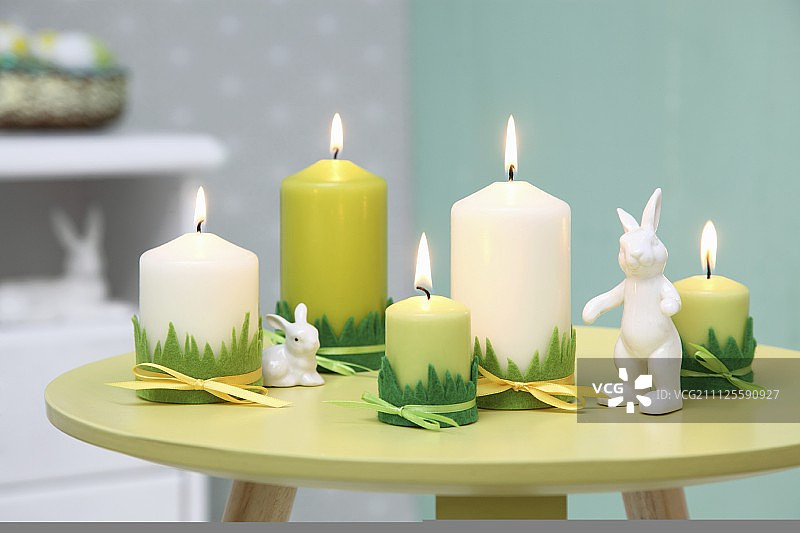 复活节的绿色安排;小圆桌上有草装饰和兔子装饰的蜡烛图片素材