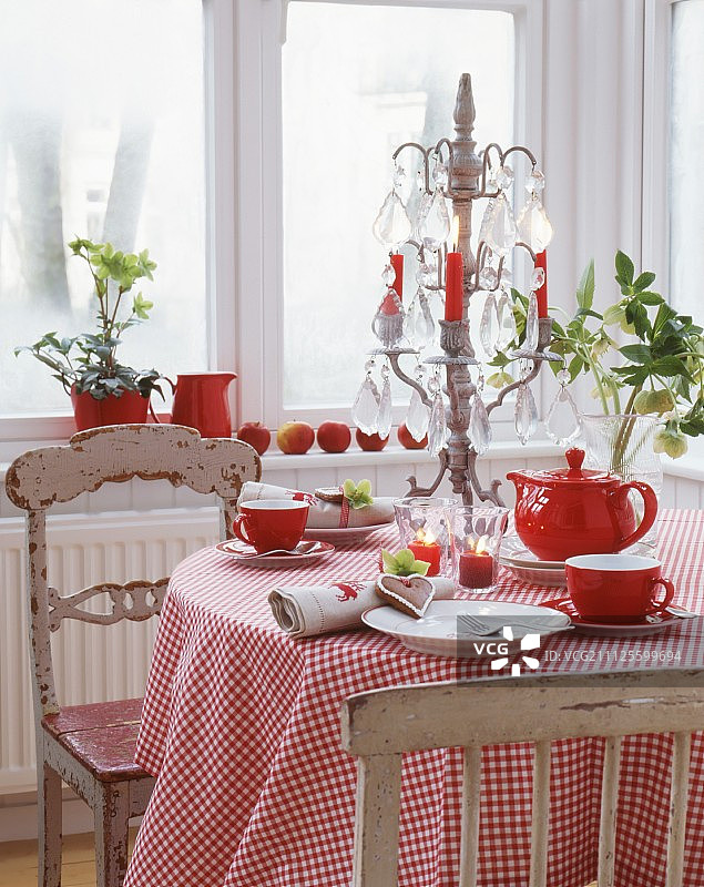 红白相间的咖啡桌上铺着格子布桌布，还有大烛台和旧椅子图片素材