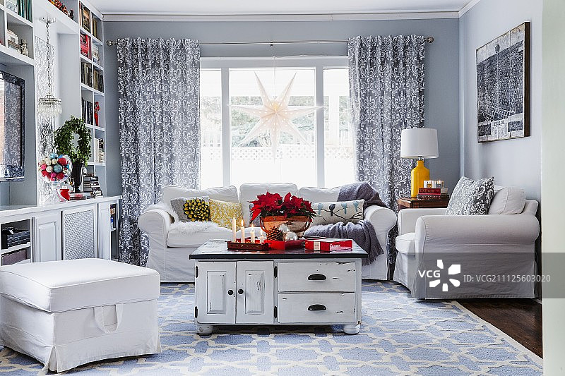 在用降临节装饰的客厅里，在淡蓝色图案的地毯上的复古桌子图片素材