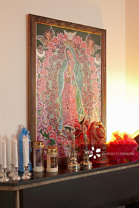 暗色表面上的神龛，墙上挂着一幅装裱好的宗教画图片素材