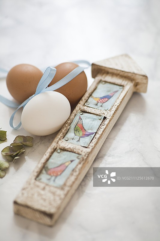 用丝带和大理石表面的木制路标装饰的鸡蛋图片素材