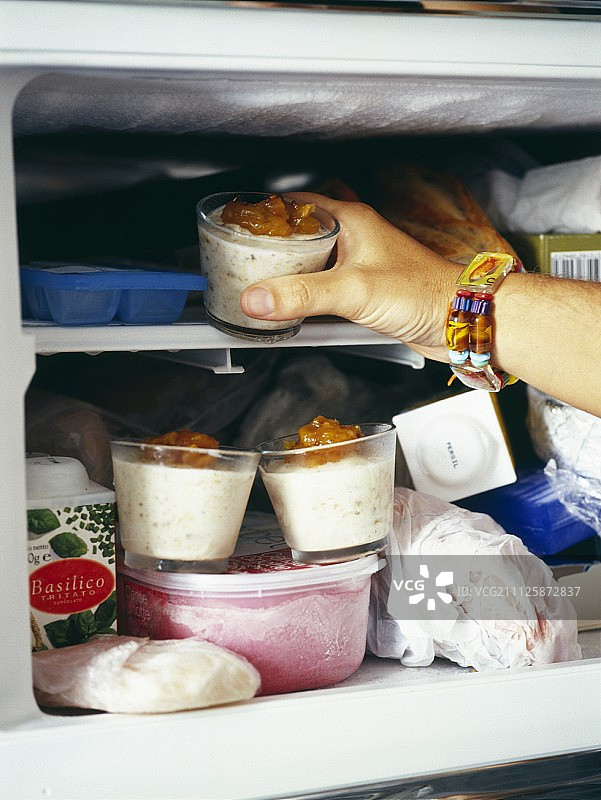 从冰箱里拿食物的人图片素材