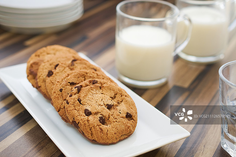 巧克力饼干和牛奶放在深色的木桌上图片素材
