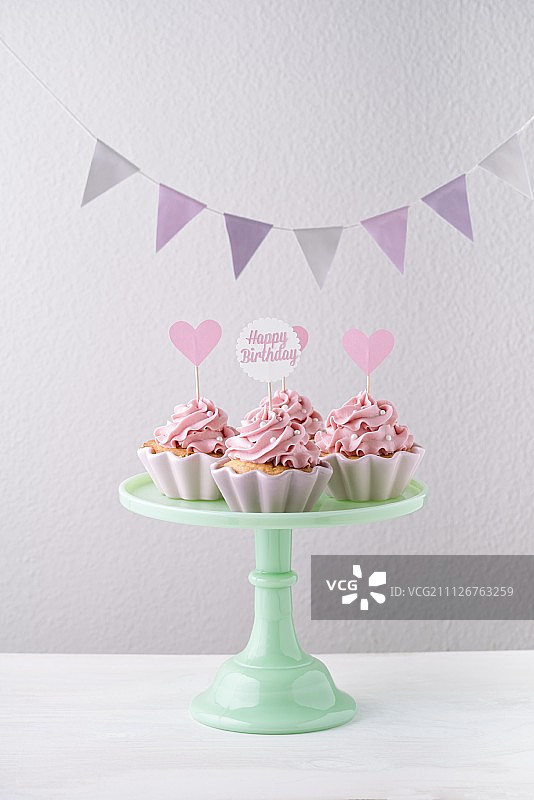 生日派对上的粉色奶油蛋糕和彩旗图片素材