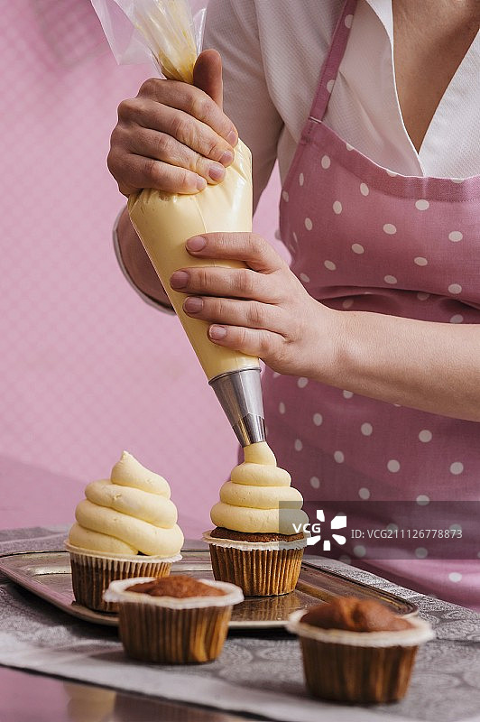 一个用芒果奶油装饰的纸杯蛋糕图片素材