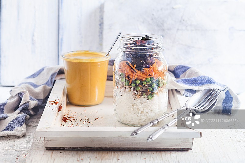 玻璃罐里的米饭沙拉，绿豆苗，豌豆，胡萝卜和迷迭香，泰国花生和辣椒酱(素食主义者)图片素材