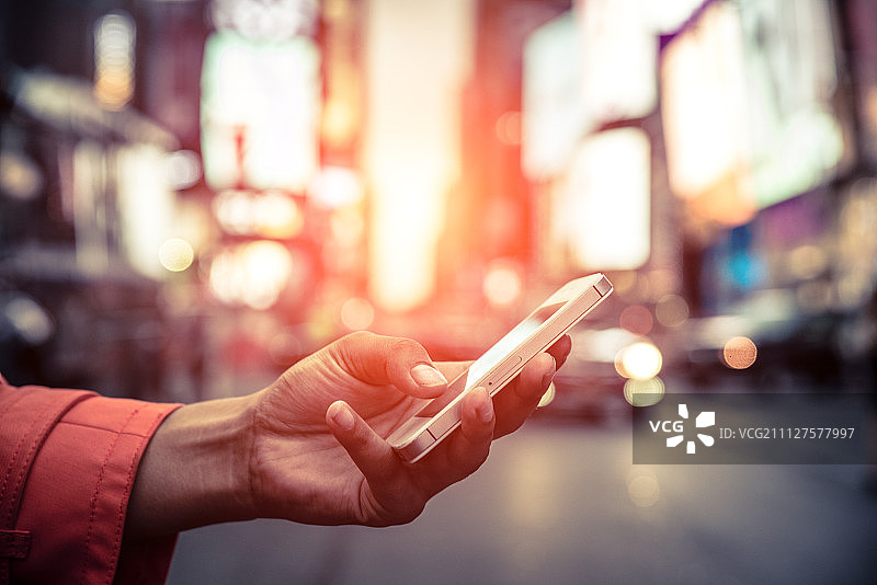 一名美国妇女在时代广场用智能手机看短信图片素材