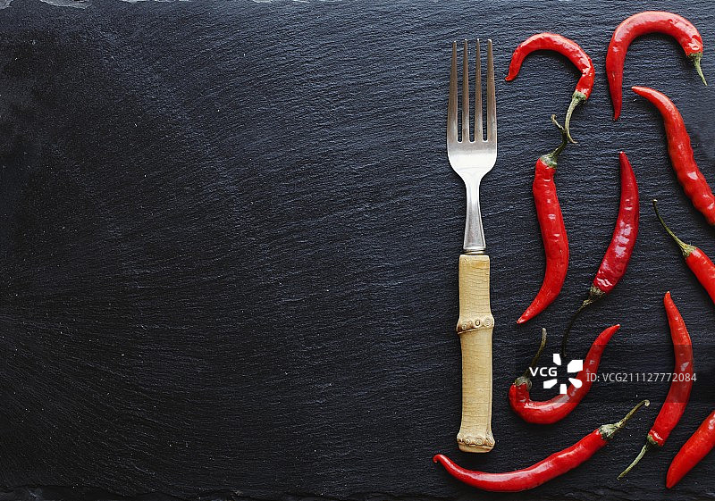 红辣椒放在木桌上，用叉子，概念，俯视图图片素材
