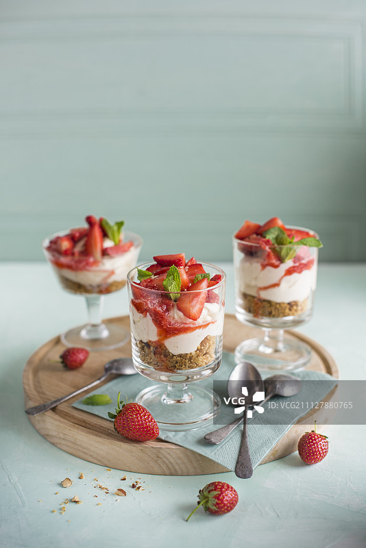 草莓和香草芝士蛋糕与坚果饼干的基础上，在小玻璃杯图片素材