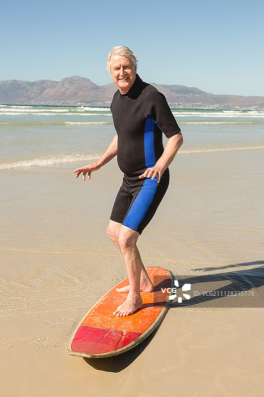 男子站在海滩冲浪板上的肖像图片素材