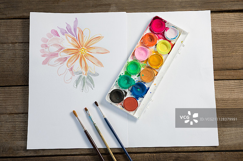 彩色调色板的特写，画笔和纸在木制表面图片素材