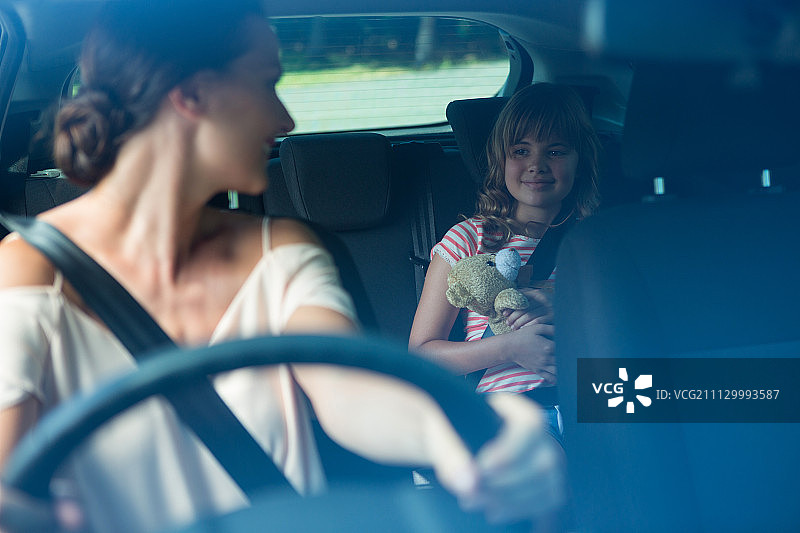快乐的女人开车，而女儿坐在后座上图片素材
