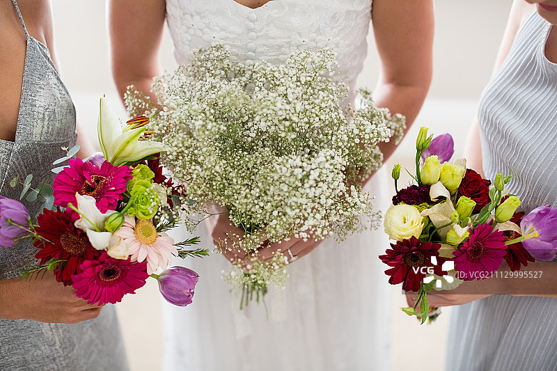 新娘和伴娘拿着花束站在家里图片素材