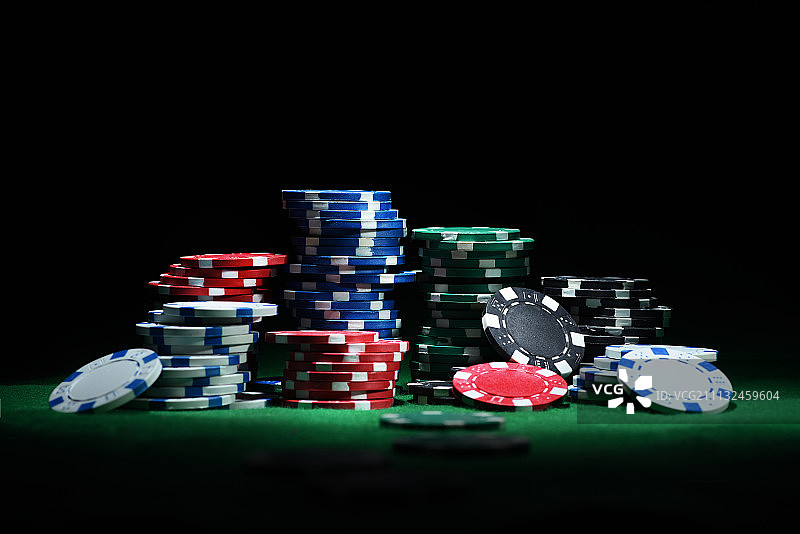 近距离拍摄的组扑克筹码在绿色的桌子上图片素材