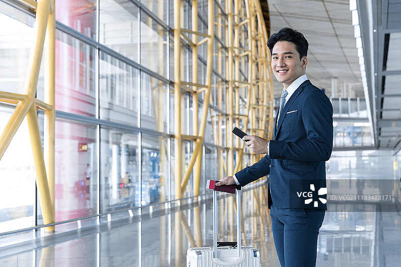 年轻商务男士拉着行李在机场图片素材