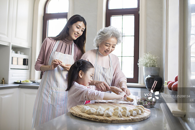 快乐的家庭在厨房包饺子图片素材
