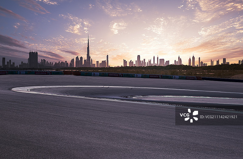 逆光下的迪拜CBD摩天大楼远景和F1汽车赛道图片素材