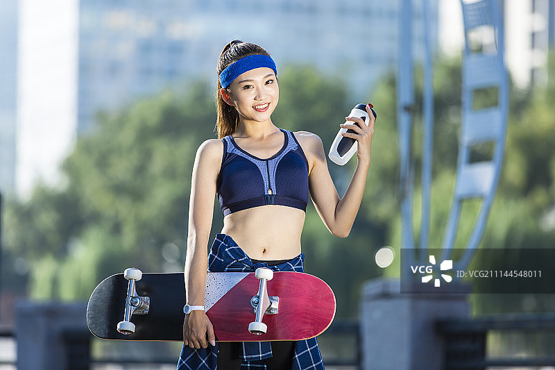 年轻女子拿着滑板图片素材