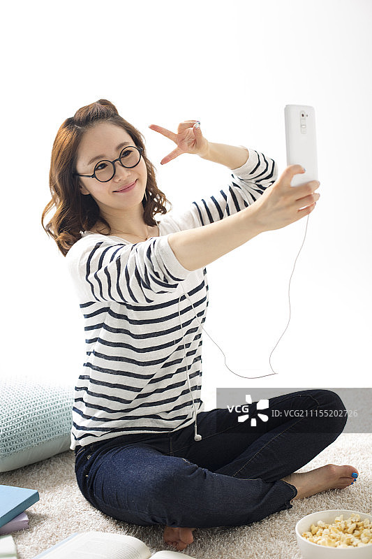 女人在家用手机自拍聊天的照片图片素材