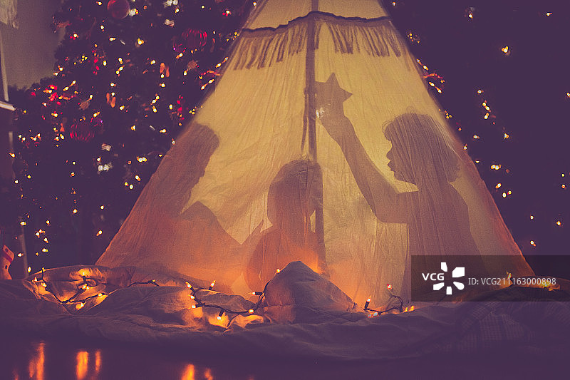 孩子们在圣诞树前的帐篷里图片素材